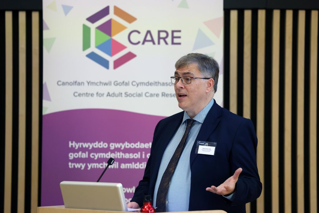 Photograph of Albert Heaney CBE, Chief Social Care Officer for Wales speaking at the Centre for Adult Social Care (CARE) Launch event.