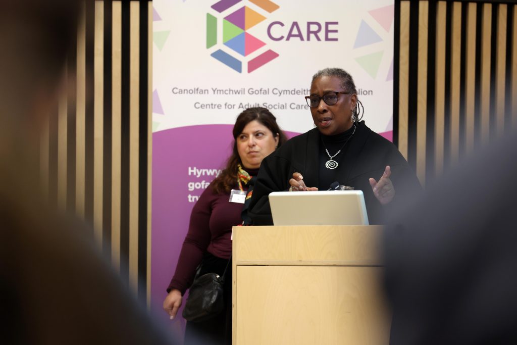 Photograph of Jazz Browne, Chief Executive of Nubian Life Resource Centre, speaking at the Centre for Adult Social Care Research (CARE) launch event with Dr Sofia Vougioukalou standing behind her.