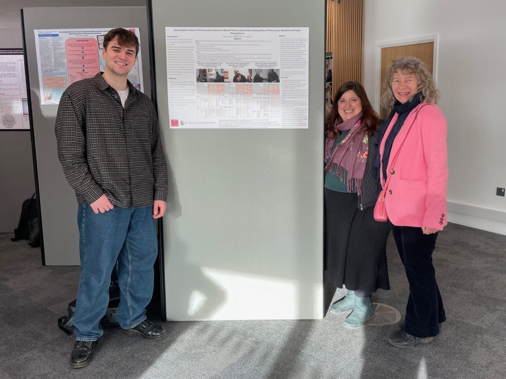 A photo of student Joseph McCartney and his supervisors next to his poster describing his research.